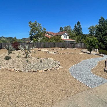 back yard converted to a succulent garden with gravel hardscape and dry river bed