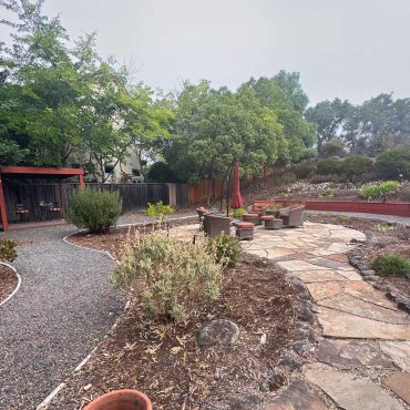 overgrown flagstone terrace with planting bed around it